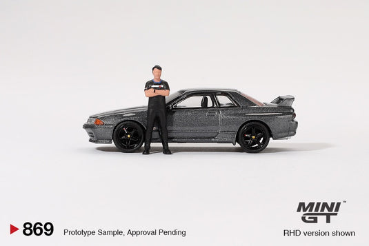 NISSAN SKYLINE GT-R (R32) NISMO NISMO GUNMETAL AVEC FIGURINE TSUGIO MATSUDA 1992 MINI GT 1:64